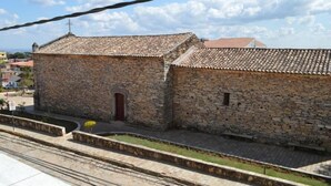 A stone building with a tiled roof, a small door, and a window. - Pousada Souza Reis (Sao Thome das Letras)