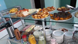 A buffet with various food items and drinks. - Pousada Souza Reis (Sao Thome das Letras)