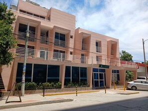A multi-story building with a flat facade, large windows, and a balcony on the upper floor. - Hotel Boutique Bahia Plaza (Santa Marta)
