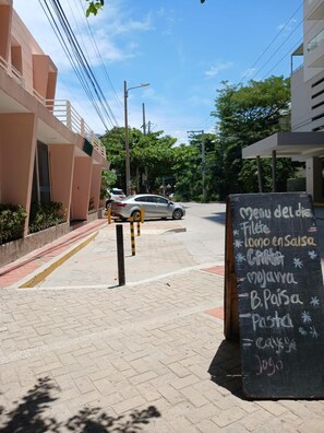 A street view with a chalkboard menu listing food items. - Hotel Boutique Bahia Plaza (Santa Marta)