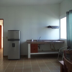 A compact kitchen with a refrigerator, a sink, and a window. - Hotel Boutique Bahia Plaza (Santa Marta)