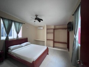 A bedroom with a bed, a ceiling fan, a wardrobe, and a TV. - Hotel Boutique Bahia Plaza (Santa Marta)