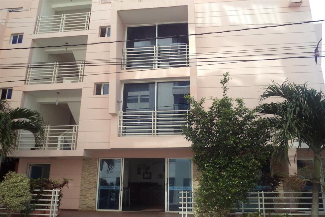 Un immeuble à plusieurs étages doté de balcons, de grandes fenêtres et d’une entrée sécurisée par un portail.