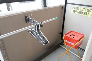 A metal handrail attached to a wall, a red storage box, and a sign with Japanese text. - Grand Court Namba 402 (Osaka)