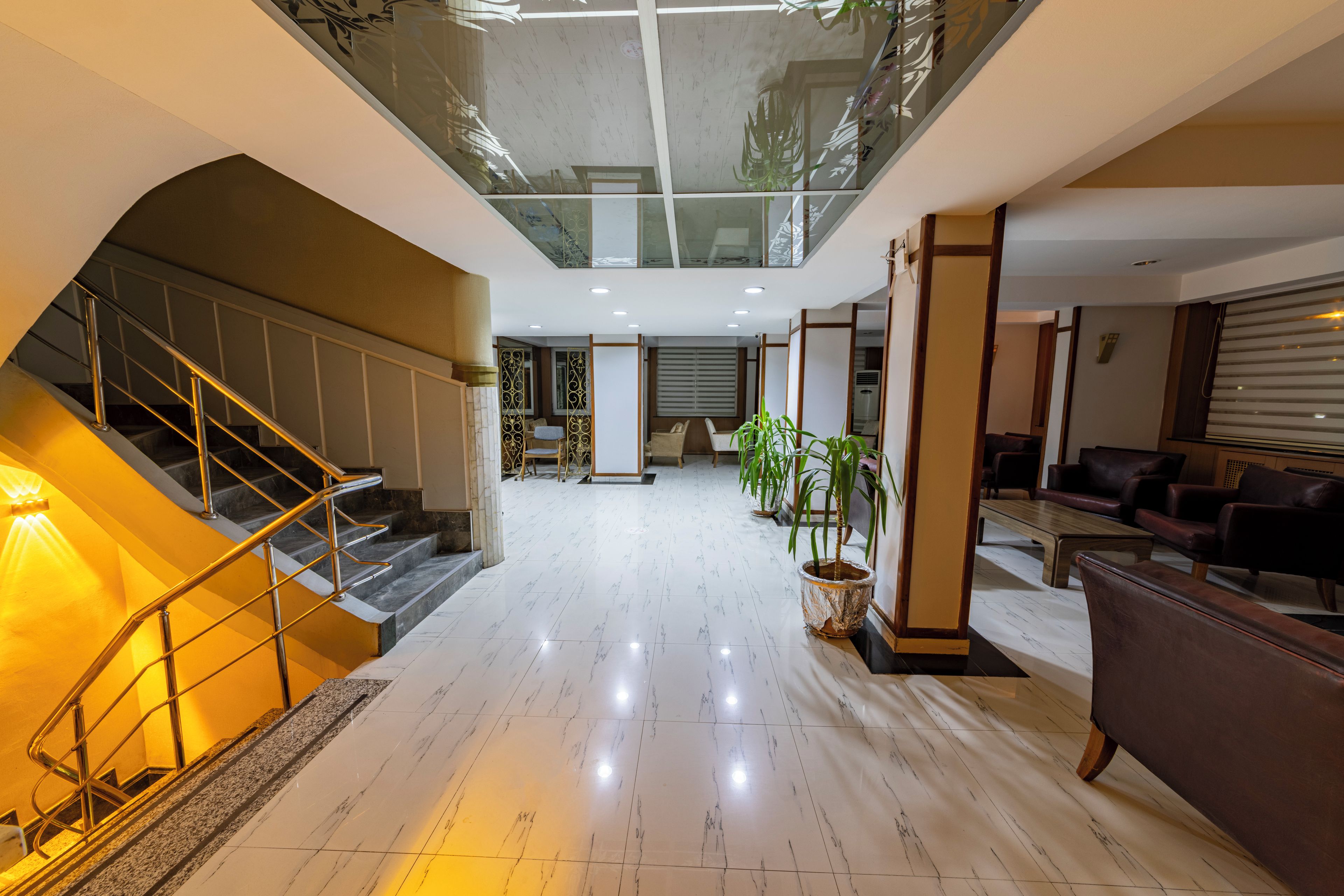 Un interior moderno con una escalera, una zona de estar y un techo de cristal.