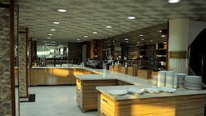A modern kitchen with wooden cabinetry, a marble countertop, and a tiled floor. - Lion City Hotel Ankara (Ankara)