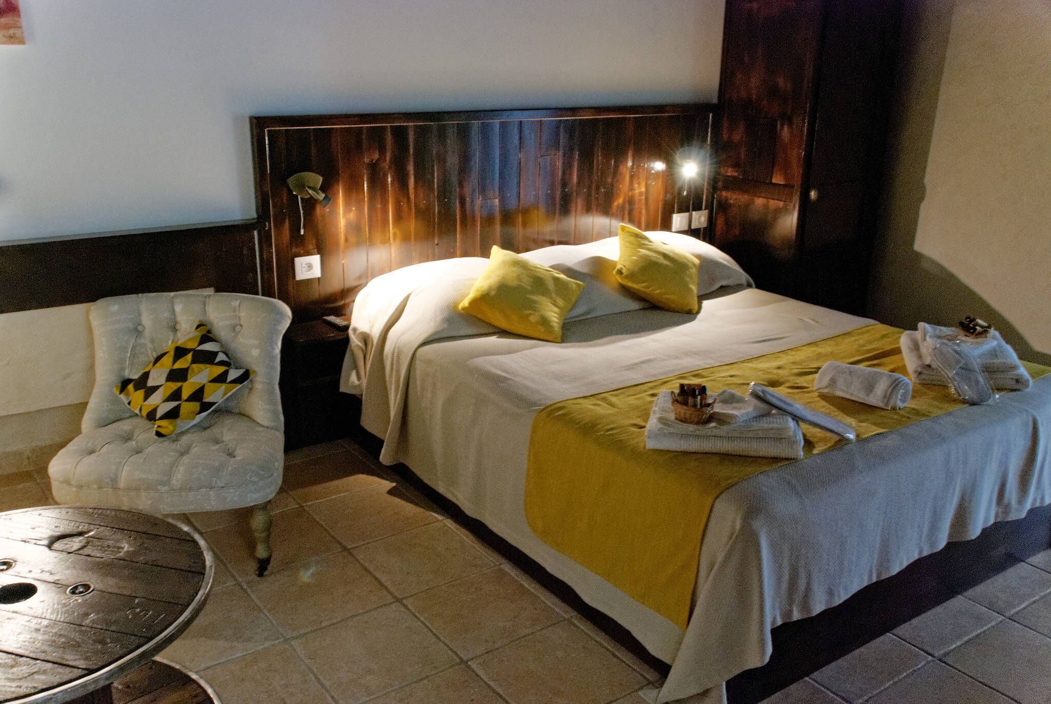 Une chambre d’hôtel avec un lit, une chaise, une table et une table de chevet.