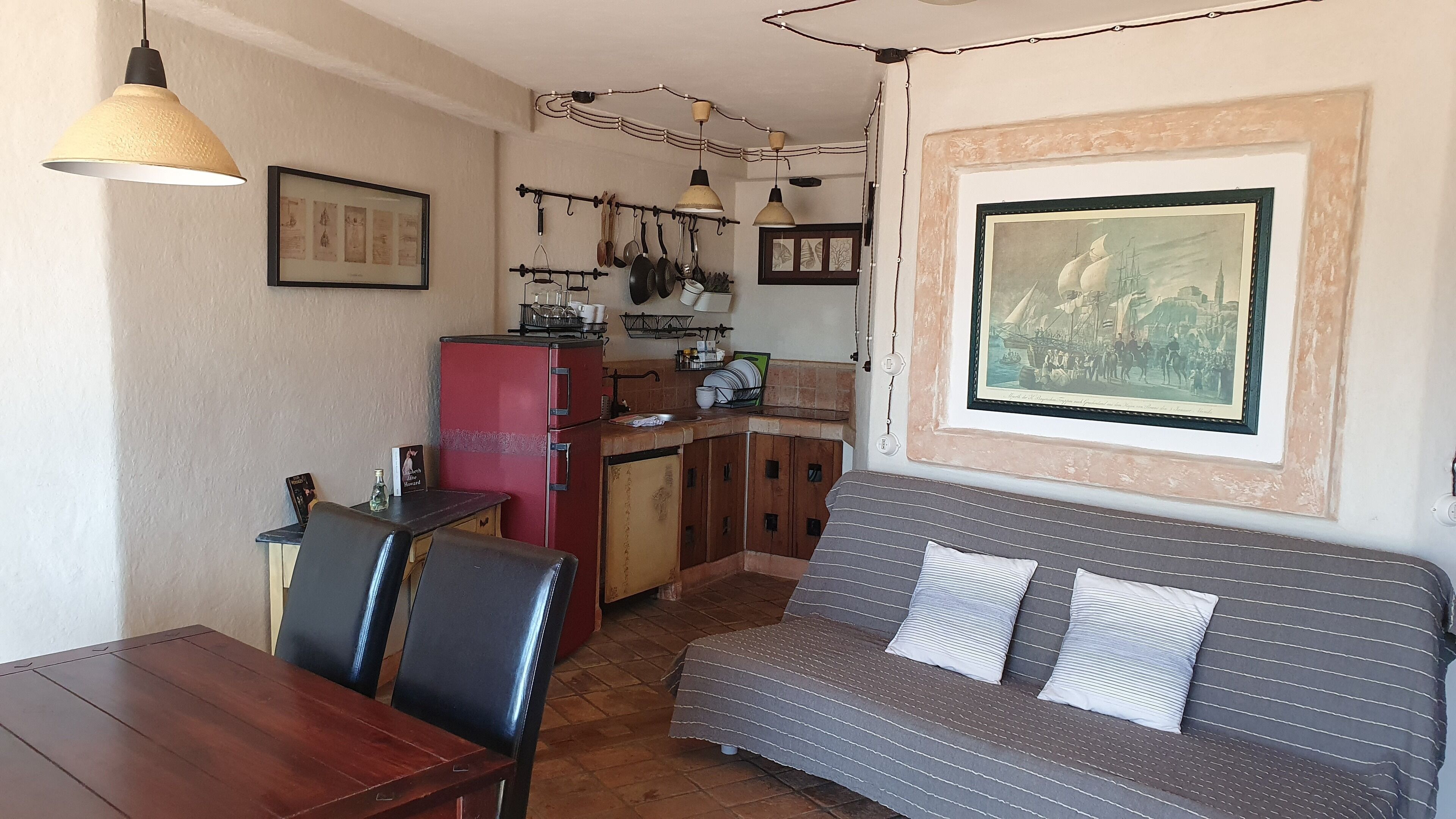 Un espacio habitable compacto con kitchenette, comedor y sofá.