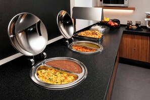 Montaje de bufé con diversos alimentos y un microondas.