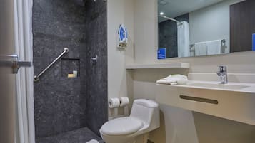 A modern bathroom with a shower, toilet, and sink.
