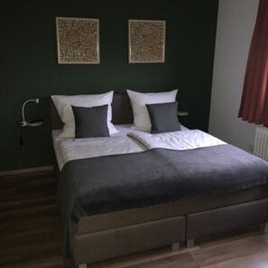 Ein Schlafzimmer mit einem Bett, zwei Nachttischen und zwei Wandpaneelen.