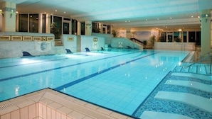 An indoor swimming pool with clear lanes, a changing room area, and a staircase leading to an upper level. - Fantastic vacation apartment "Waldhonig" (St. Englmar)