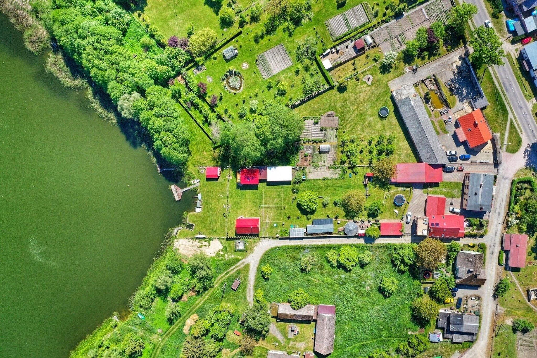 An aerial view of a residential area with houses, a dock, and a body of water.