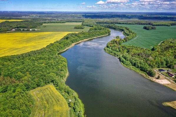 A river meandering through a landscape with fields and forested areas.