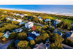Vista aérea de una zona residencial costera con casas, caminos y una playa.