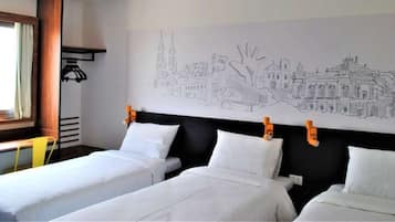 A hotel room with two single beds, a large wall mural, a window with curtains, and a yellow chair.