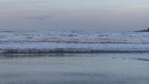 Uma praia com ondas e céu claro.