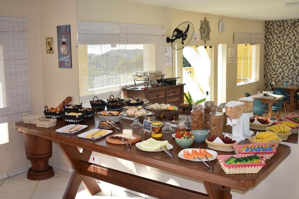 A buffet table with various food items and a fan in the background.