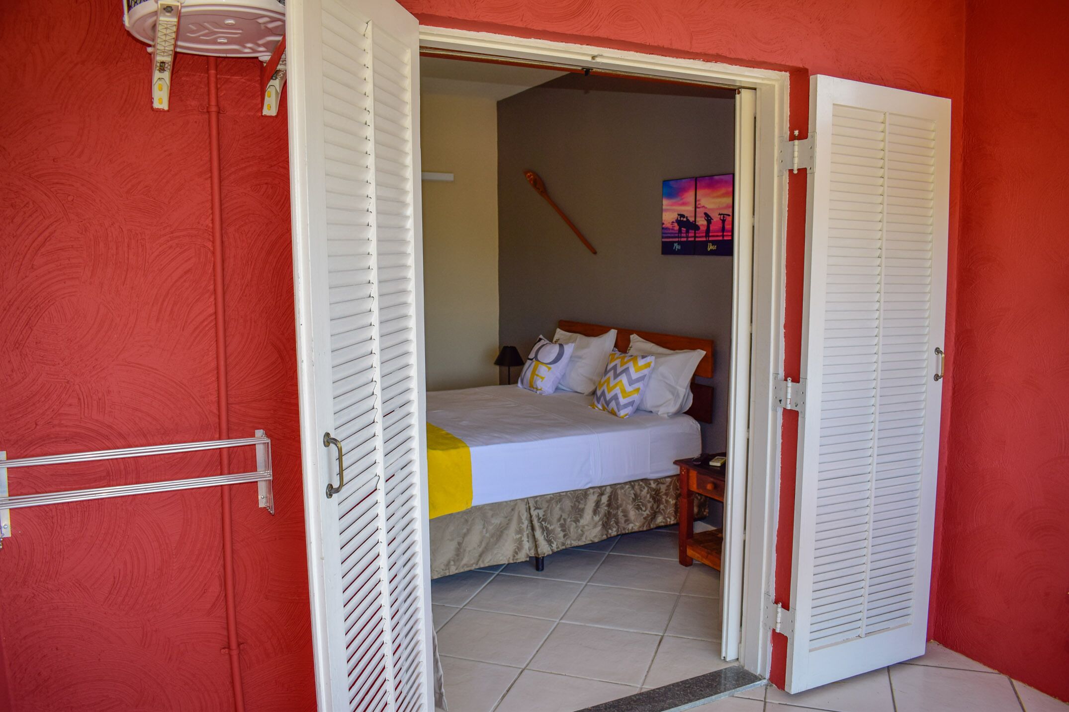 Un dormitorio con cama, mesita de noche y un cuadro en la pared.