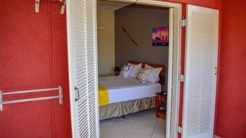 Un dormitorio con cama, mesita de noche y un cuadro en la pared.
