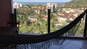 Uma rede em um quarto com vista para uma cidade costeira.