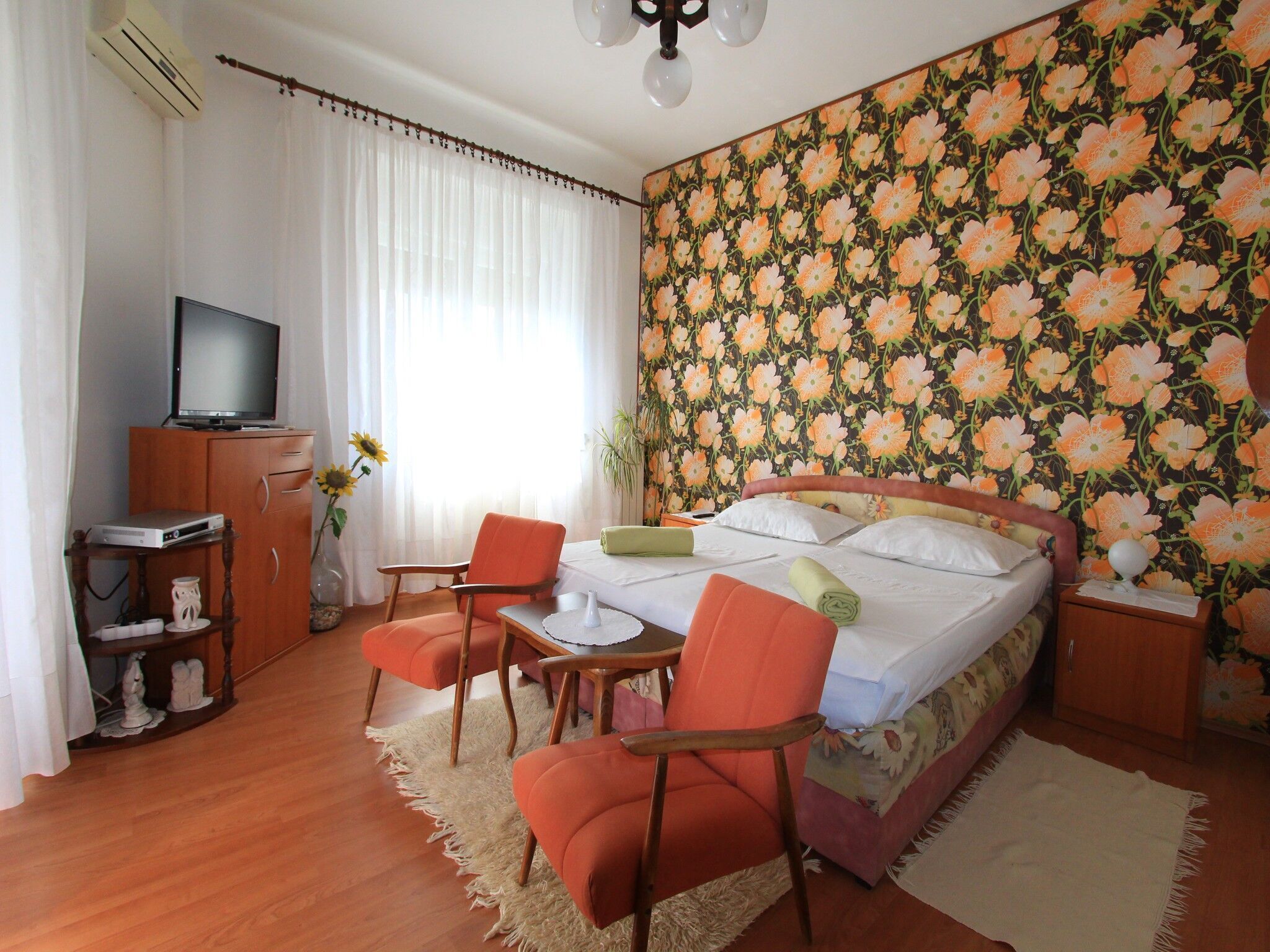 Une chambre à coucher avec un lit, une télévision, un bureau et une chaise.