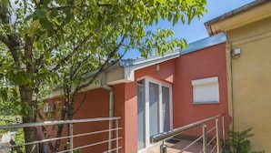 A red building with a metal staircase and a door with shutters. - Apartments Vilma (Crikvenica)