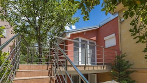 A staircase with metal railings leading to a balcony with a beige awning. - Apartments Vilma (Crikvenica)