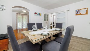 Een eethoek met een rechthoekige tafel gedekt voor vier personen, omringd door stoelen.