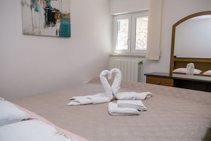 A hotel room with a bed, a window, a radiator, and a painting on the wall. - Apartment Karmen (Moscenicka Draga)