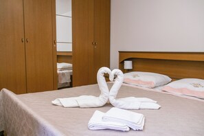 Hotellihuone, jossa on sänky, puinen vaatekaappi ja peili.
