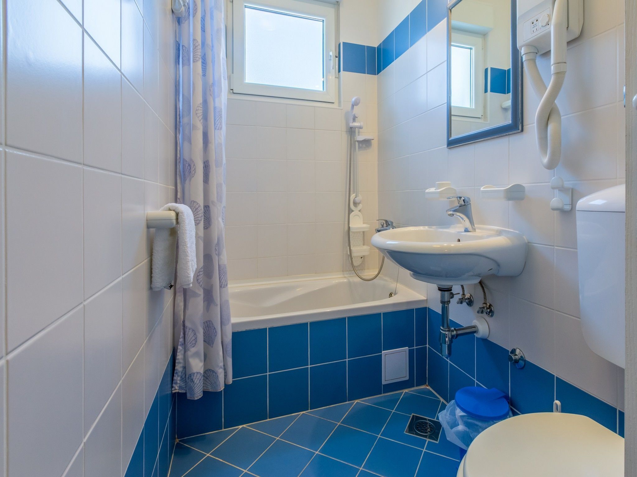 Een badkamer met een bad, een wastafel en een toilet.