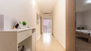 A narrow hallway with a bed, a dresser, and a small plant. - Apartment Cherry Garden (Zemunik Donji)