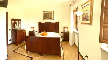 A bedroom with a wooden bed, bedside tables with lamps, a dresser, and a mirror.