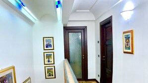 A staircase with a handrail, wooden flooring, and framed pictures on the walls. - La Fornace del Sole (Capannori)