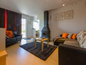 A living room with a fireplace, two sofas, a coffee table, and a rug.
