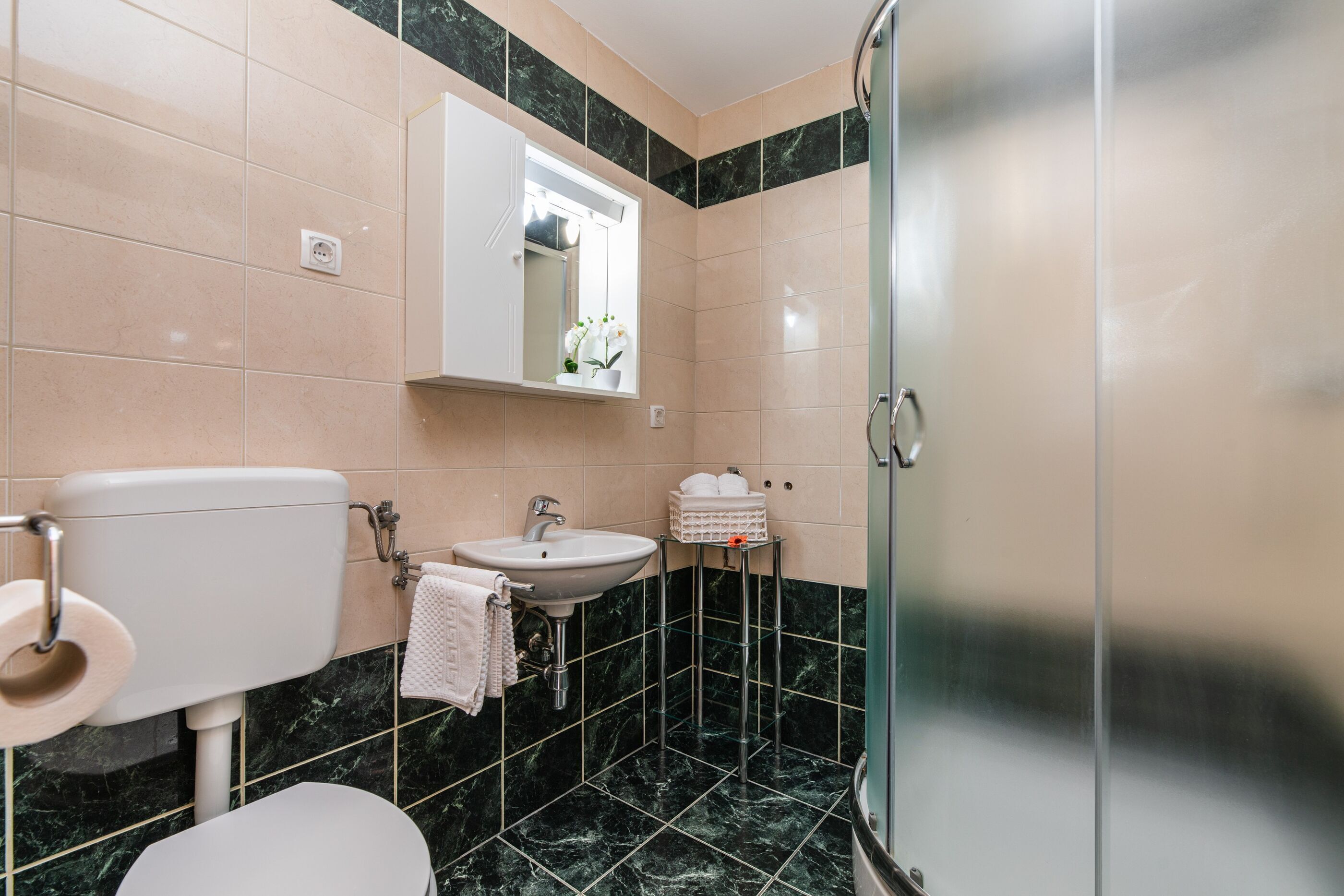 A bathroom with a toilet, sink, and shower.