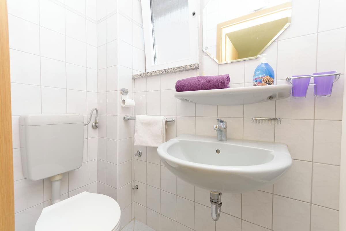 Ein Badezimmer mit Toilette, Waschbecken und einem Spiegel darüber.