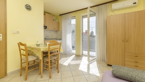 A compact living space with a dining area, kitchenette, and a balcony. - Apartment and Room Ilija (Tribunj)