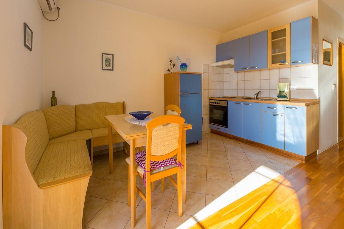 A compact living space with a sofa, dining table, and a kitchenette.
