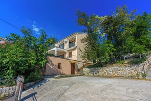Un bâtiment à deux étages doté d’un mur en pierre et d’un balcon.