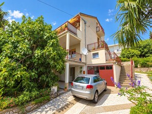 A multi-story residential building with a car parked in front. - Apartment Mia (Crikvenica)
