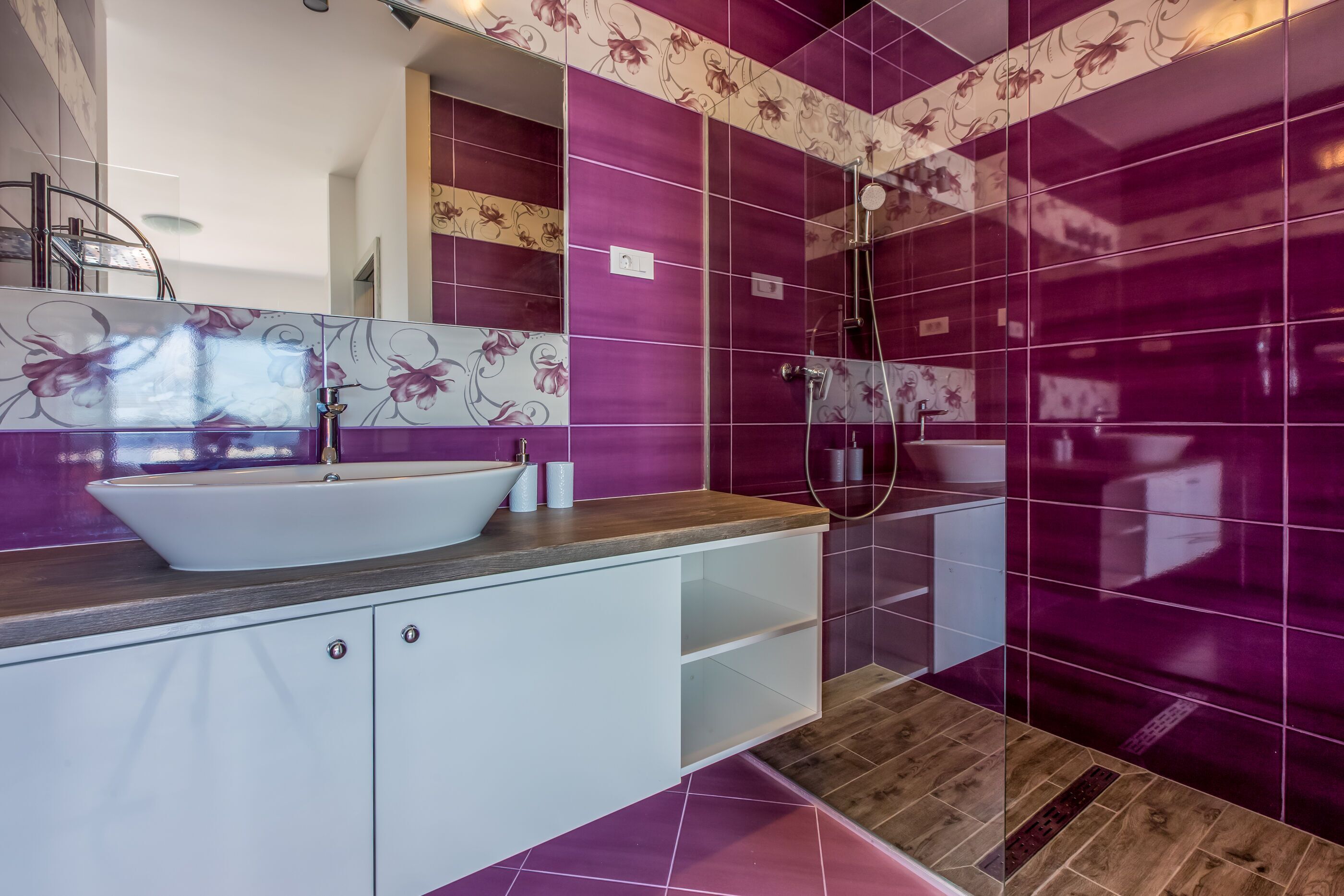 Une salle de bain moderne avec un grand lavabo blanc, un plan de travail en bois et un espace douche.
