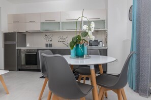 A modern kitchen with a dining area. - Apartments Zorica (Crikvenica)