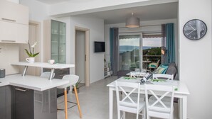 Un espace de vie moderne comprenant une cuisine, un coin repas et un balcon avec vue.
