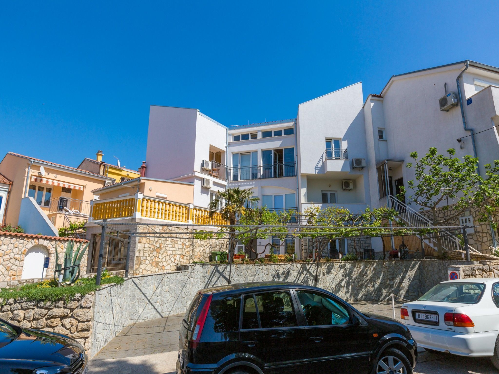 Un edificio moderno con varios balcones y una pared de piedra.