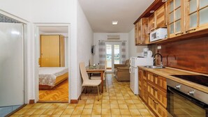 Eine kleine Küche mit Holzausstattung, einer Mikrowelle, einer Kaffeemaschine und einer Essecke mit Tisch und Stühlen.