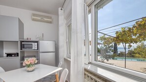 Une cuisine compacte équipée d’un four à micro-ondes, d’un petit réfrigérateur et d’un coin repas avec une table et des chaises.