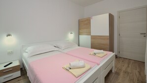 Une chambre moderne avec un lit double, une armoire et une table de chevet.