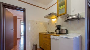 Una cocina compacta equipada con lavavajillas, cafetera y tostadora.